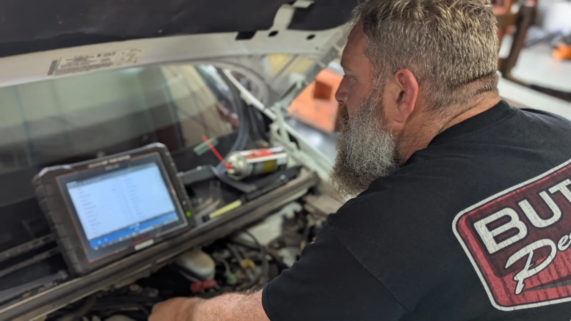 Technician using diagnostic scan tool at Patriot Garage Yukon